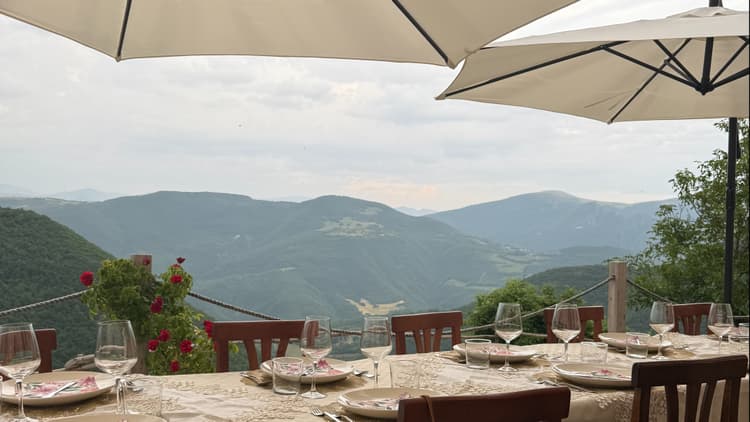 Travelers rescuing lunch from the rain in a countryside garden in Umbria