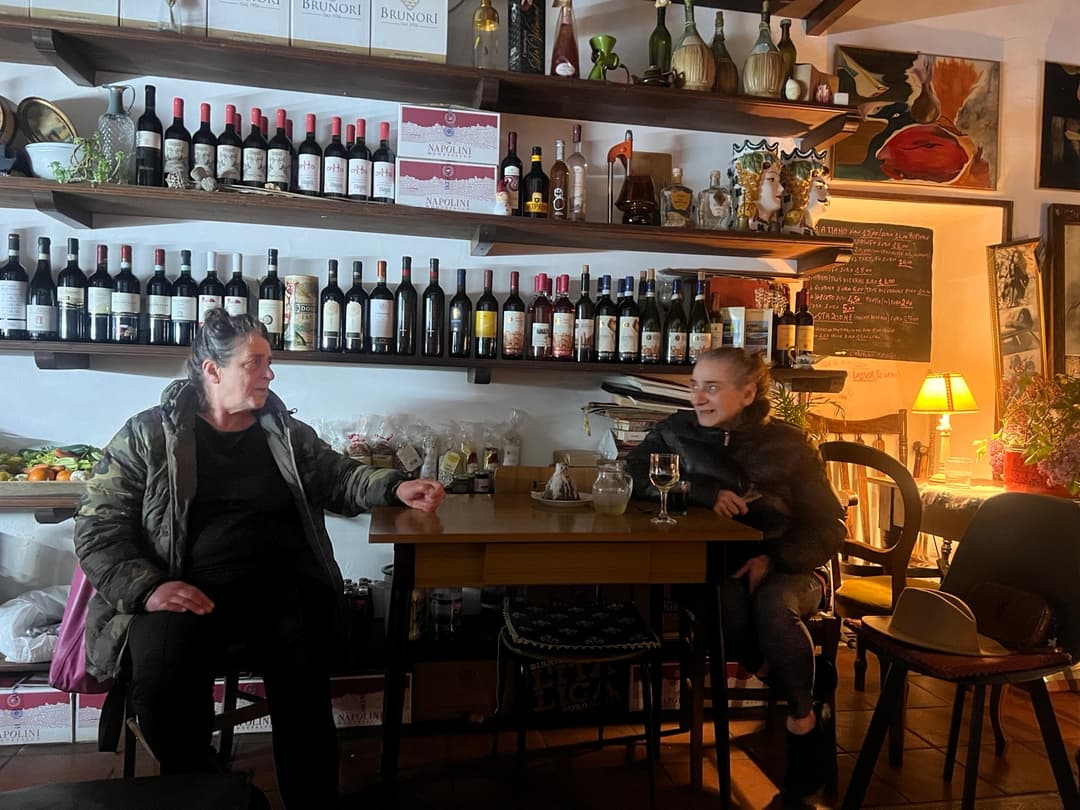 Titi and Lila sharing a warm conversation inside Cucina Umbra