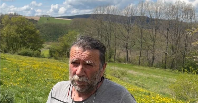 Uncle Pio holding a black truffle beside a truffle dog in an Umbrian forest