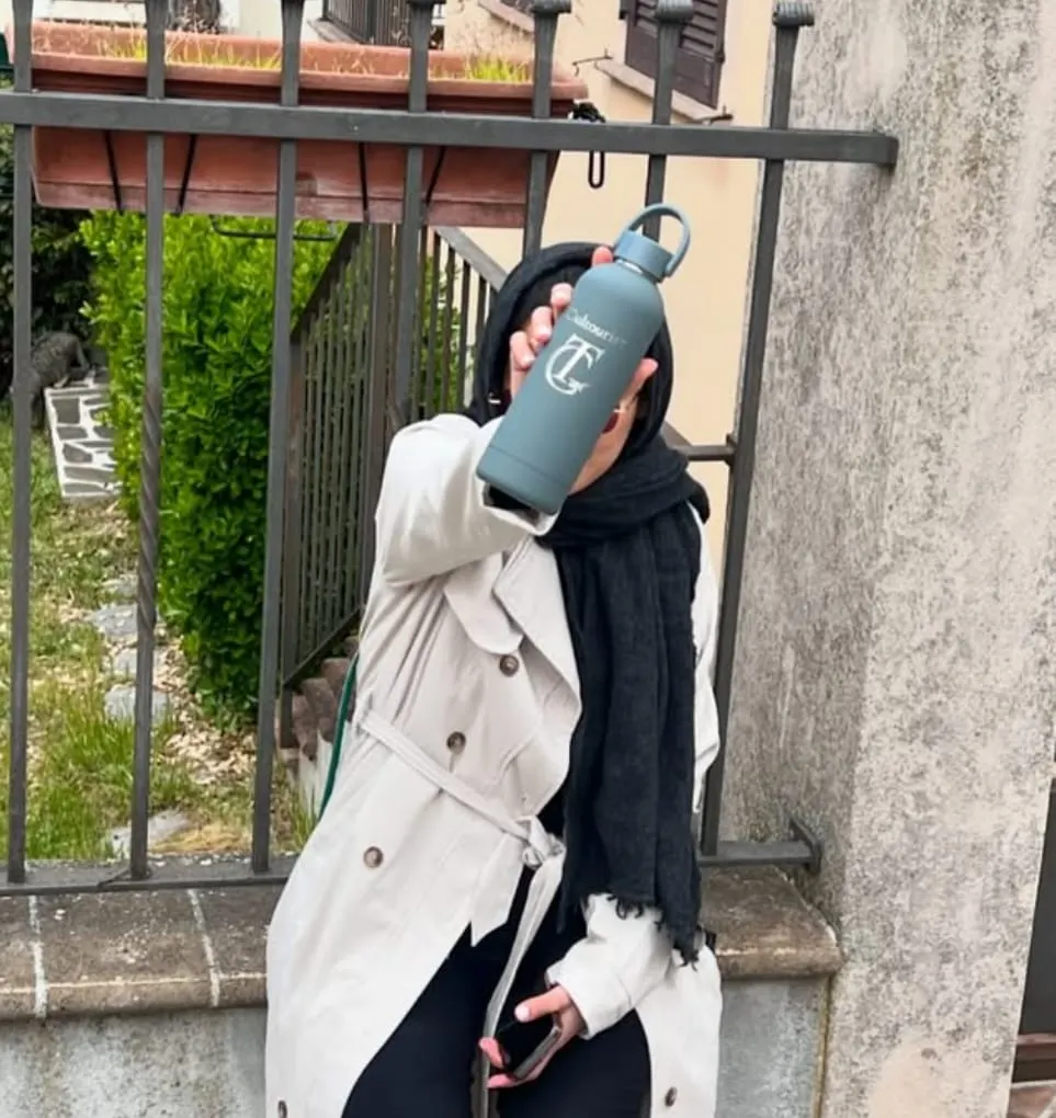 A traveller holding up a Cultouristers water bottle
